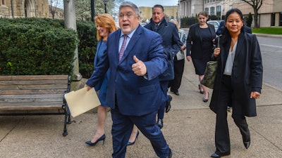Attorney General for the State of West Virginia Patrick Morrisey, center, gives a thumbs up as he walks to the entrance of the Kanawha County Courthouse in Charleston, W.Va., on Monday, April 4, 2022, the first day of the trial against Janssen Pharmaceuticals Inc., Teva Pharmaceuticals Inc., Allergan and their family of companies.