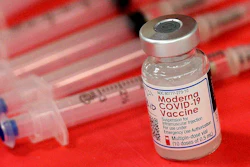 Syringes and a vial of the Moderna COVID-19 vaccine are displayed at a mass COVID-19 vaccination site in Batavia, Ill., on March 19, 2021. Moderna hopes to offer updated COVID-19 boosters in the fall that combine its original vaccine with protection against the omicron variant. On Tuesday, April 19, 2022, it reported a preliminary hint that such an approach might work.