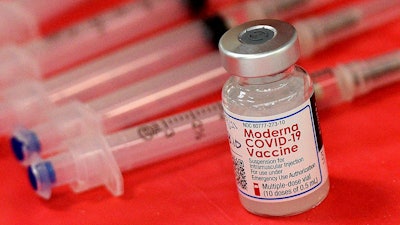 Syringes and a vial of the Moderna COVID-19 vaccine are displayed at a mass COVID-19 vaccination site in Batavia, Ill., on March 19, 2021. Moderna hopes to offer updated COVID-19 boosters in the fall that combine its original vaccine with protection against the omicron variant. On Tuesday, April 19, 2022, it reported a preliminary hint that such an approach might work.