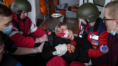 Ambulance paramedics move a civilian wounded in shelling onto a stretcher to a maternity hospital converted into a medical ward in Mariupol, Ukraine, March 2, 2022. A bipartisan group of U.S. lawmakers is calling on the Biden administration to establish field hospitals near Ukraine's border and ramp up medical support for what's expected to be a months-long war of attrition waged by Russia.