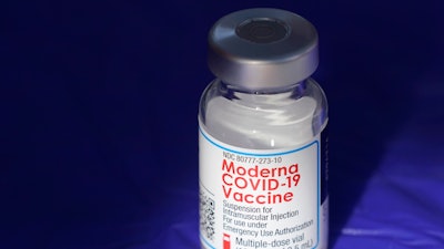 In this March 4, 2021 file photo, a vial of the Moderna COVID-19 vaccine rests on a table at a drive-up mass vaccination site in Puyallup, Wash., south of Seattle. COVID-19 vaccine sales helped Moderna triple its net income in a better-than-expected first quarter. The vaccine maker said Wednesday, May 4, 2022, that revenue from its coronavirus preventive shots jumped to $5.92 billion from $1.73 billion in last year’s quarter, when the vaccines were debuting in most markets.