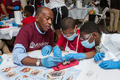 Meharry President Dr. James Hildreth helps two middle schoolers with dissecting a frog in October 2016 in Nashville, Tenn, during Meharry NOW, a program where Meharry faculty, students and staff 'take over' two Nashville middle schools for a day and encourage young students to find out how fascinating science and biology can be. The Meharry NOW program will hopefully encourage students to look toward science or health care careers as they head to higher grades.