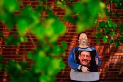 Sara Atkins poses for a photo, in Wynnewood, Pa., Tuesday, May 10, 2022, while holding a pillow with an image of her father Andy Rotman-Zaid, who died of COVID-19 in December 2020. She channels her grief into fighting for global vaccination and better access to health care to honor her father.