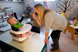 Amy McCoy signs to a baby about food as a toddler finishes lunch behind at her Forever Young Daycare facility, Monday, Oct. 25, 2021, in Mountlake Terrace, Wash. According to a report released by the Centers for Disease Control and Prevention on Tuesday, May 24, 2022, U.S. births bumped up in 2021, but the number of babies born was still lower than before the coronavirus pandemic.