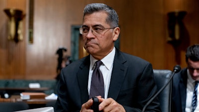 Health and Human Services Secretary Xavier Becerra arrives for a hearing on Capitol Hill in Washington, April 5, 2022. Medicare recipients will get a premium reduction — but not until next year. That reflects what Becerra says was an overestimate in costs of covering a costly and controversial new Alzheimer's drug.