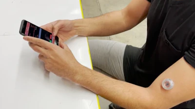 The device can be worn on the upper arm and sends data wirelessly to a custom smartphone app.