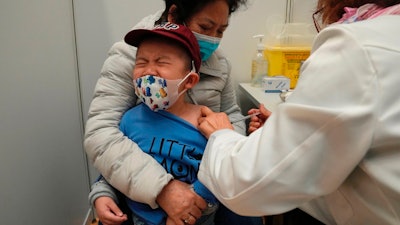 A boy receives a dose of China's Sinovac COVID-19 coronavirus vaccine at a community vaccination center in Hong Kong on Feb. 25, 2022. U.S. government advisers met Wednesday, June 15, 2022 to decide whether to endorse COVID-19 shots for babies, toddlers and preschoolers, moving the nation closer to vaccinations for all ages. According to the World Health Organization, 12 countries are vaccinating kids under 5.