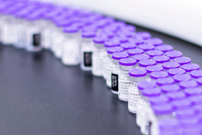 In this March 2021 photo provided by Pfizer, vials of the Pfizer-BioNTech COVID-19 vaccine are prepared for packaging at the company's facility in Puurs, Belgium. According to a study published Thursday. June 23, 2022 in the journal Lancet Infectious Diseases, nearly 20 million lives were saved by COVID-19 vaccines during their first year, but even more deaths could have been prevented if global targets had been reached.