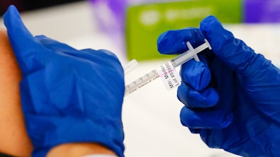 A health worker administers a dose of a Moderna COVID-19 vaccine during a vaccination clinic in Norristown, Pa. on Dec. 7, 2021. In a reversal for President Joe Biden, a federal appeals court in New Orleans on Monday, June 27, 2022, agreed to reconsider its own April ruling that allowed the administration to require federal employees to be vaccinated against COVID-19.