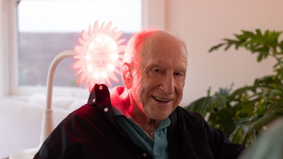 A senior using a Sunflower during his morning routine. Photobiomodulation is shown to reverse cognitive decline for people living with Alzheimer's.