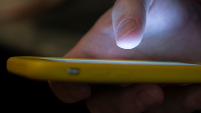 In this Sunday, Aug. 11, 2019, photo, a man uses a cell phone in New Orleans. Quick help for suicidal thoughts and other mental health emergencies may soon be as easy as 9-8-8. The United States’ first nationwide three-digit mental health crisis hotline goes live on Saturday, July 16, 2022.
