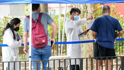 Healthcare workers with New York City Department of Health and Mental Hygiene help people register for the monkeypox vaccine at one of the City's vaccination sites, Tuesday, July 26, 2022, in New York. The World Health Organization recently declared that the expanding monkeypox outbreak is a global emergency.