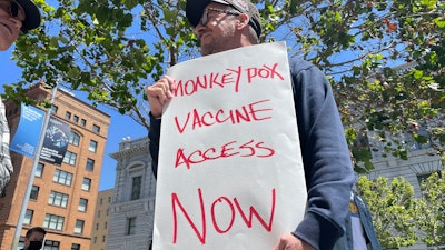 A man holds a sign urging increased access to the monkeypox vaccine during a protest in San Francisco, July 18, 2022. California's governor on Monday, Aug. 1, 2022, declared a state of emergency to speed efforts to combat the monkeypox outbreak, becoming the second state in three days to take the step.