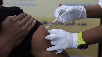 A man receives the AstraZeneca COVID-19 vaccine at Jabra Hospital in Khartoum, Sudan, Thursday, March 11, 2021. A new philanthropic project hopes to invest $100 million in up to 10 countries mostly in Africa by 2030 to support up to 200,000 community health workers.