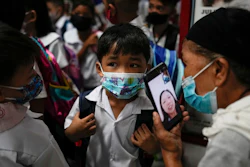 A boy talks to his mother from a smartphone during the opening of classes at the San Juan Elementary School in metro Manila, Philippines on Monday, Aug. 22, 2022. Millions of students wearing face masks streamed back to grade and high schools across the Philippines Monday in their first in-person classes after two years of coronavirus lockdowns that are feared to have worsened one of the world's most alarming illiteracy rates among children.