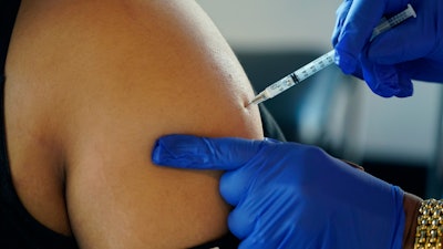 A Jackson, Miss., resident receives a Pfizer booster shot from a nurse at a vaccination site Feb. 8, 2022. The Biden administration hopes to make getting a COVID-19 booster as routine as going in for the yearly flu shot.
