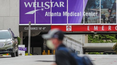 A masked man passes Wellstar Atlanta Medical Center on Boulevard in Atlanta on May 20, 2020. WellStar announced late Wednesday, Aug. 31, 2022, that the Atlanta Medical Center will close in two months after experiencing more than $100 million in losses over the past year.