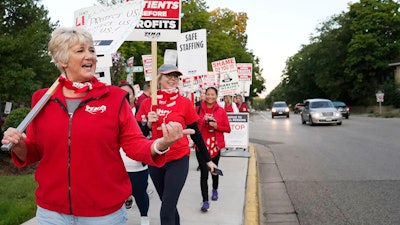Mary Turner, president of the Minnesota Nurses Association, left, joins nurses striking Monday, Sept. 12, 2022 outside North Memorial Health Hospital in Robbinsdale, Minn. Nurses launched a three-day strike over issues of pay and what they say is understaffing that has been worsened by the strains of the coronavirus pandemic.
