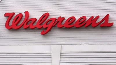 The Walgreens logo on the front of a store, Wednesday, July 14, 2021, in Cambridge, Mass. Walgreens is spending nearly $1.4 billion to buy the remaining stake in Shields Health Solutions it doesn’t already own and continue pushing into the fast-growing area of specialty pharmacy.