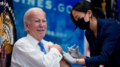President Joe Biden receives his COVID-19 booster from a member of the White House medical unit during an event in the South Court Auditorium on the White House campus, Tuesday, Oct. 25, 2022, in Washington.