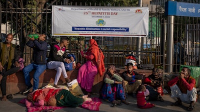 Patients and their attendants squat outside the All India Institute of Medical Sciences (AIIMS) hospital in New Delhi, India, Wednesday, Dec. 7, 2022.