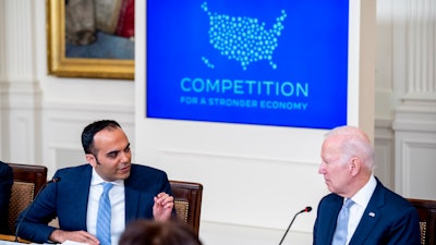 Consumer Financial Protection Bureau director Rohit Chopra, left, accompanied by President Joe Biden, right, speaks at a meeting with his Competition Council on the economy and prices in the East Room of the White House in Washington, Wednesday, Feb. 1, 2023.