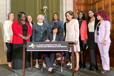 New York Gov. Kathy Hochul, center, signs bills expanding reproductive healthcare that will allow people in New York to receive contraceptives without a doctor's prescription, Tuesday, May 2, 2023, in Albany, N.Y.