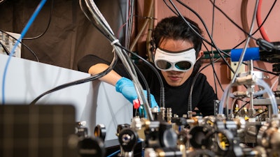 Qizhong Liang, a PhD candidate in JILA and the Department of Physics at the University of Colorado Boulder, demonstrates how the laser-based breathalyzer works, in the Ye lab at JILA.