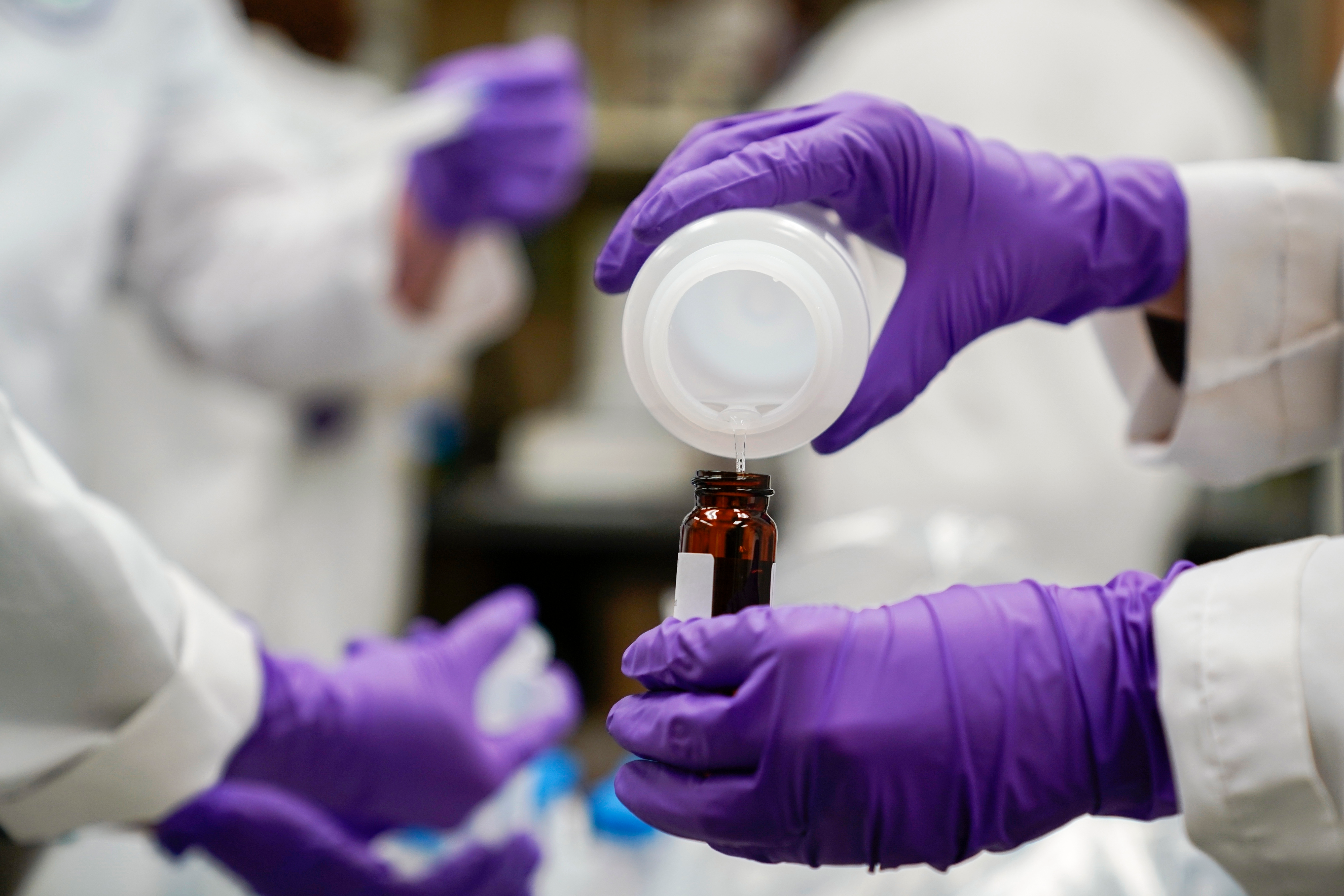 Eva Stebel, water researcher, pours a water sample at the EPA Center for Environmental Solutions and Emergency Response, Cincinnati, Feb. 16, 2023.