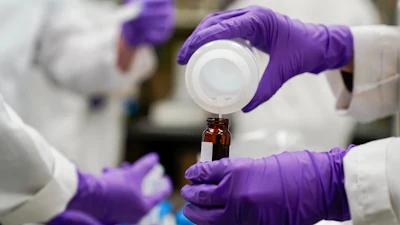 Eva Stebel, water researcher, pours a water sample at the EPA Center for Environmental Solutions and Emergency Response, Cincinnati, Feb. 16, 2023.