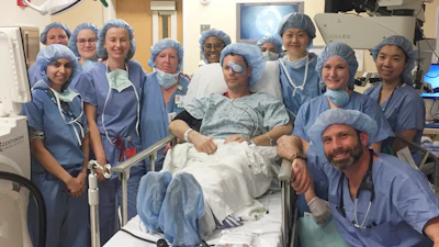 This photo provided by Mass Eye and Ear Phil Durst sits with the surgical team after the first transplant procedure in Boston in April 2018.