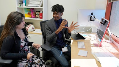 Post-doctoral researcher Tofunmi Omiye, right, gestures while talking in his office with assistant professor Roxana Daneshjou at the Stanford School of Medicine in Stanford, Calif., Tuesday, Oct. 17, 2023.