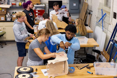 This photo released by Tulane University shows Tulane biomedical engineering students building specially designed mobility chairs for children at the MakerSpace workshop at the university Sunday, Sept. 24, 2023. The students are making the second batch of mobility chairs for toddlers, that will eventually go to pediatric patients at Children's Hospital. Wheelchairs are expensive, and insurance won't cover the cost for children unless the child proves they can operate it independently.
