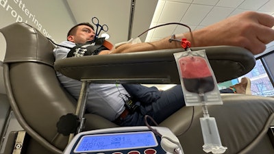 Aaron Posey, a Bloodworks Northwest executive, donates blood at the blood center's Seattle headquarters on Dec. 14, 2023.