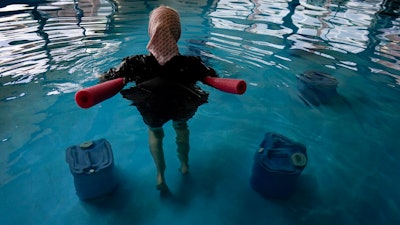 An Amish woman from Ohio floats with a pool noodle among BioHealing generators at the Tesla Wellness Hotel and MedBed Center on Wednesday, Nov. 15, 2023, in Butler, Pa.