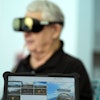 A screen displays a visual of being in a Navy fighter jet as retired Army Col. Farrell Patrick, 91, wears a Mynd Immersive virtual reality headset at John Knox Village, Wednesday, Jan. 31, 2024, in Pompano Beach, Fla.