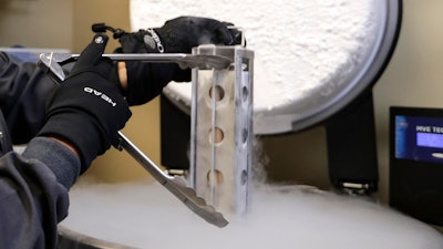 A container with frozen embryos and sperm stored in liquid nitrogen is removed at a fertility clinic in Fort Myers, Fla., Tuesday, Oct. 2, 2018. The Alabama Supreme Court ruled, Friday, Feb. 16, 2024, that frozen embryos can be considered children under state law, a ruling critics said could have sweeping implications for fertility treatments. The decision was issued in a pair of wrongful death cases brought by three couples who had frozen embryos destroyed in an accident at a fertility clinic.