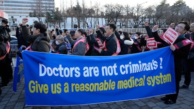 Doctors stage a rally against the government's medical policy near the presidential office in Seoul, South Korea, Sunday, Feb. 25, 2024. The South Korean government on Wednesday warned thousands of striking doctors to return to work immediately or face legal action after their collective walkouts caused cancellations of surgeries and disrupted other hospital operations.