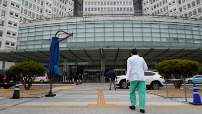A medical worker walks to enter Seoul National University Hospital in Seoul, South Korea, Thursday, Feb. 29, 2024. South Korea’s government made a last appeal to junior doctors to end a walkout, with hours left to go before the Thursday deadline on its threats to suspend medical licenses and prosecute the strikers.