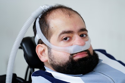 Temple University doctoral student Jaggar DeMarco poses for a photograph while utilizing a battery powered ventilator in Philadelphia, Wednesday, March 6, 2024. DeMarco waited more than three years to get his second ventilator from his health insurer.