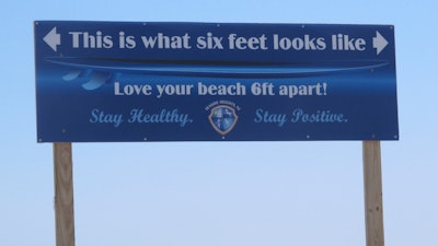 A sign on the Seaside Heights, N.J., boardwalk on May 15, 2020, advises people how far away from each other they should stay to maintain social distancing during the COVID-19 pandemic.