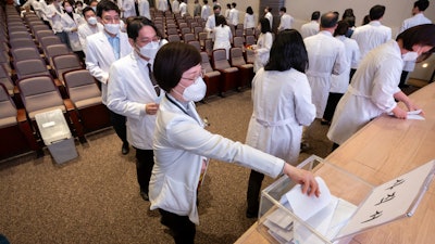 Medical professors queue to submit their resignations during a meeting at Korea University in Seoul, South Korea, Monday, March 25, 2024. Senior doctors at dozens of hospitals in South Korea planned to submit their resignations Monday in support of medical interns and residents who have been on a strike for five weeks over the government’s push to sharply increase medical school admissions, their leader said.