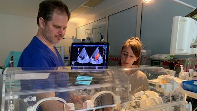 Pediatric cardiologist Dr. Holger Michel during a cardiac ultrasound examination of 7-​week-old Jarmo in the presence of his mother.
