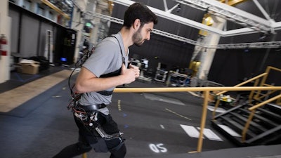 Dean Molinaro walks up an adjustable ramp while wearing an experimental exoskeleton, demonstrating how the team collected data in their effort to develop a unified control framework for robotic assistance devices.