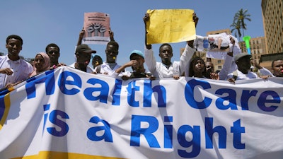 Doctors and other medical staff take part in a protest, in downtown Nairobi, Kenya, Friday, March 22, 2024. Hundreds of Kenyan doctors have protested in the streets demanding better pay and working conditions in an ongoing nationwide strike that has entered its second week. The doctors carried placards and chanted against the Kenyan government on Friday, saying it had failed to implement a raft of promises, including a collective bargaining agreement signed in 2017 after a 100-day strike during which people died from lack of care.