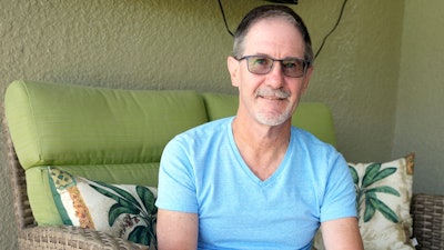 Scott Berkheiser, 57, who has Alzheimer's disease, sits for a portrait at his home Friday, April 5, 2024, in Venice, Fla. Insurance denials delayed Berkheiser’s first Leqembi infusion a few months until last December. He said the drugmaker eventually agreed to give it to him for free while he makes co-payments for the infusions. “It was a little crazy,” he said. “It seemed like it was kind of a game that must make sense for some monetary reason.”