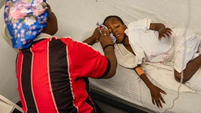 Denize Flerino wipes sweat from the brow of her son who is suffering from high fevers at a Doctors Without Borders emergency room in the Cite Soleil neighborhood of Port-au-Prince, Haiti, Friday, April 19, 2024. Haiti's health system has long been fragile, but it's now nearing total collapse after gangs launched coordinated attacks on Feb. 29, targeting critical state infrastructure in the capital and beyond.