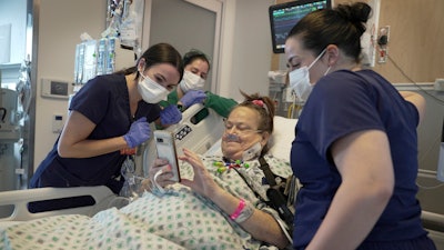 Lisa Pisano looks at photos of her dog after her surgeries at NYU Langone Health in New York on Monday, April 22, 2024. Doctors transplanted a pig kidney into Pisano, who was near death, part of a dramatic pair of surgeries that also included a fix for her failing heart.