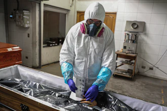 An employee takes the fingerprints of a woman who died from the new coronavirus before her remains are cremated at La Recoleta crematorium in Santiago, Chile, Saturday, June 27, 2020. Countries are still struggling to come up with an agreed-upon plan for how the world might respond to the next global outbreak. A ninth and final round of talks involving governments, advocacy groups and others to finalize a “pandemic treaty” is scheduled to end Friday, May 10, 2024.