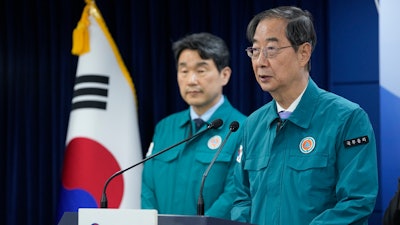South Korean Prime Minister Han Duck-soo, right, gives a public statement at the government complex in Seoul, South Korea, Thursday, May 16, 2024. A South Korean court ruled in favor of the government's contentious plan to drastically boost medical school admissions on Thursday.